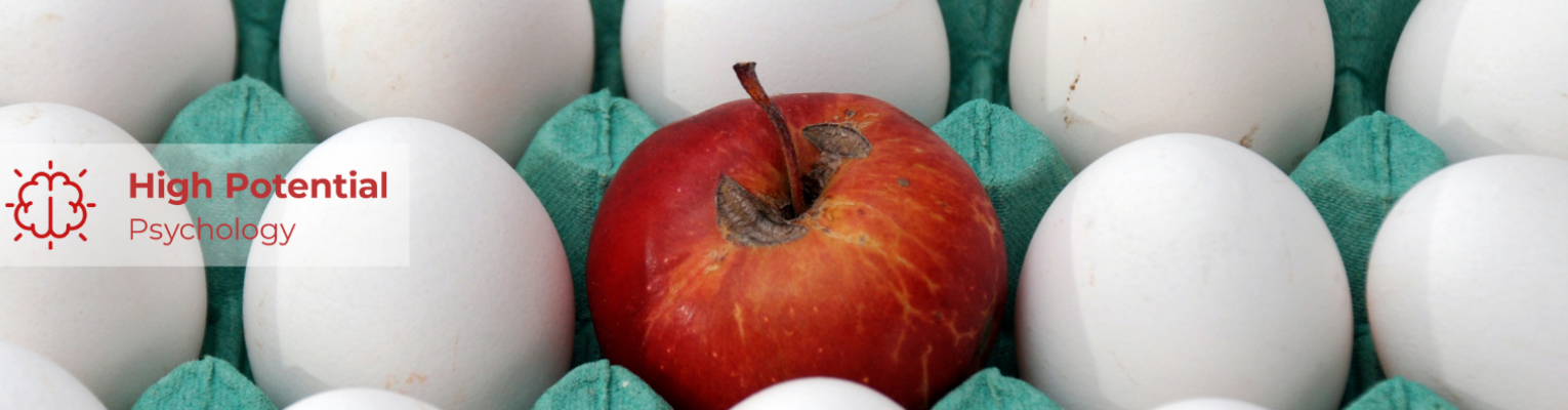 A bright red apple in a carton of white eggs