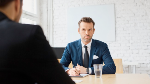 A manager sitting acoss from another person at a desk